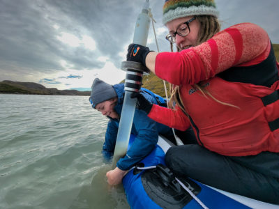 Hazuková, in front, and University of Maine researcher Jasmine Saros take a sediment core from a lake in West Greenland.