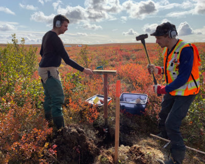Researchers Evan Wilcox [left] and Niels Weiss extract ice-rich permafrost cores [as seen in photo, right] from the tundra.