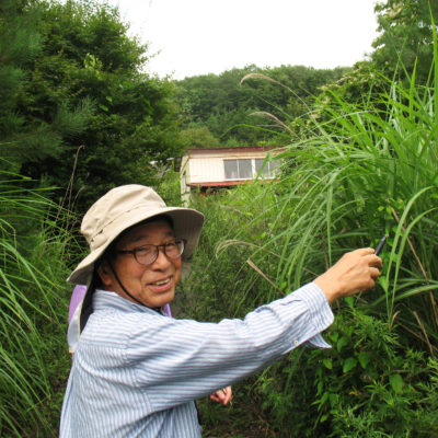 Baba Isao approaches his abandoned house in Namie.