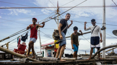 Author Ian Urbina boarding a fishing boat off the Philippines while investigating the mysterious death of a deckhand. 