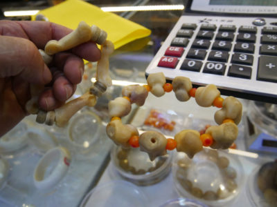 Jewelry made from lion bones for sale in an Asian market. Dealers tell potential buyers that the pink-hued beads are the result of the animal being deboned while still alive.