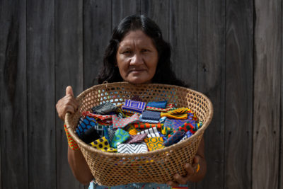 Bekwyitexo Kayapó, chief of Pukany village, holds a basket of beaded bracelets that she and other Kayapó women make and sell.