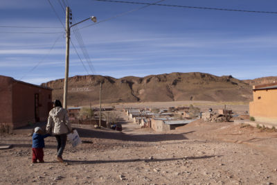 A mother and her child, both Indigenous Kolla, walk through Susques, Argentina near the Salinas Grandes lithium plant.
