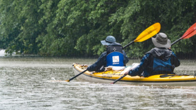 Members of the expedition paddle though rain.