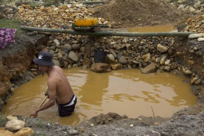 A miner digs a trench to pan for gold near the Mali River.