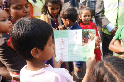 Left: Batteries disassembled for lead recycling in Patna, India. Right: A boy in Patna reads a pamphlet warning of the dangers of lead exposure. 