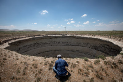 Geologist Fetullah Arik takes measurements at a sinkhole in Konya Province in June. The lack of rain has forced farmers to draw down groundwater, causing massive sinkholes to form.
