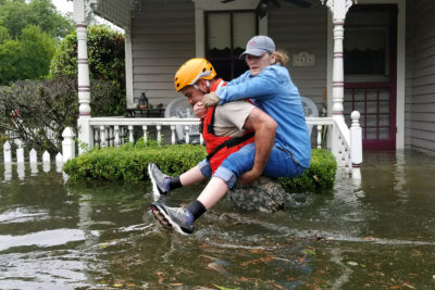 A Texas National Guardsman carries a resident from her flooded home following Hurricane Harvey in Houston, Aug. 27, 2017. 