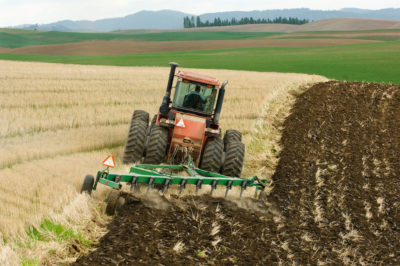 A tractor plows a field of wheat stubble on a traditional farm near Pullman, Washington.