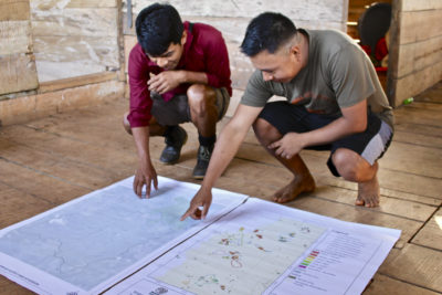 Wounaan forest technicians review maps showing areas of fires and deforestation. 