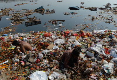 Men search for coins and recyclable items along the banks of New Delhi's Yamuna River.