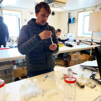 Scientist Jacob Strock examines microscopic particles of plastic trapped in sea ice.