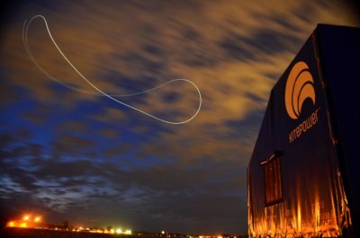 This long-exposure nighttime photograph shows the figure-eight flight pattern of Kitepower's airborne wind system.