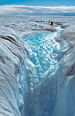 Meltwater pours into one of hundreds of deep holes recently observed in the Greenland ice sheet.